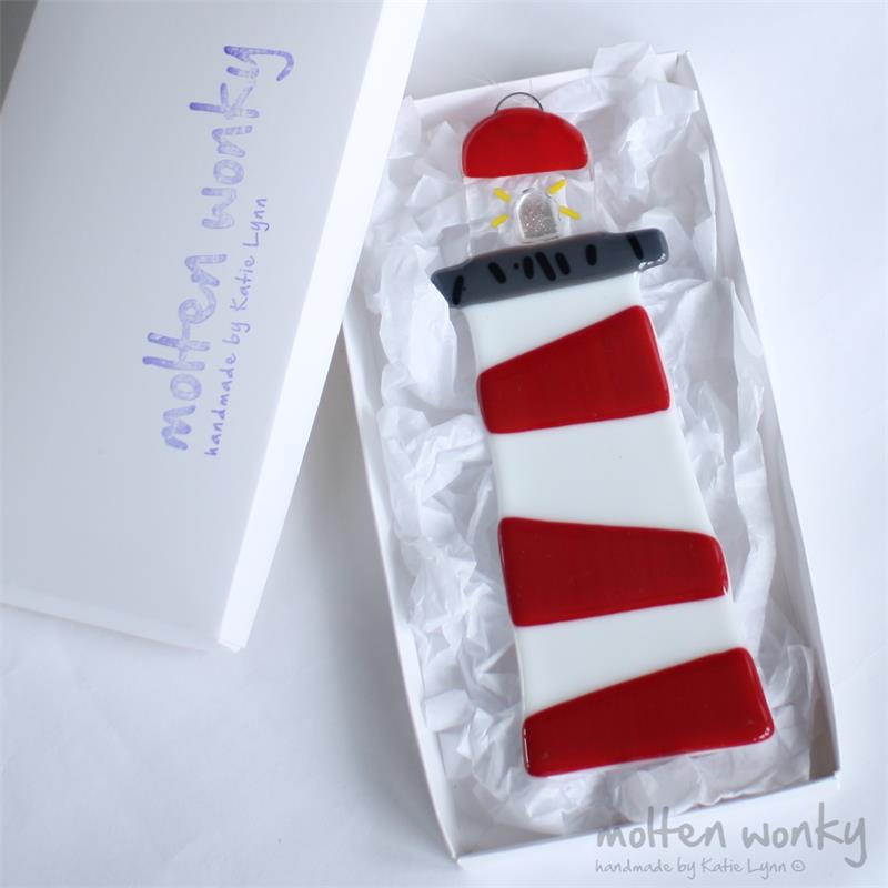 Handmade fused glass lighthouse with shining light